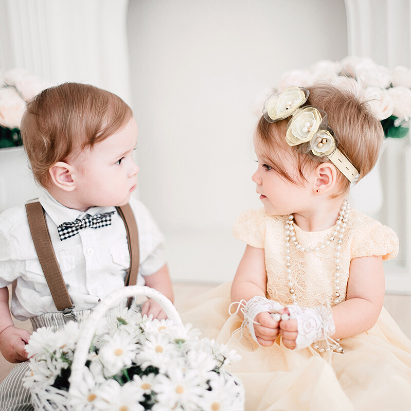 zwei kleine Kinder mit Blumenkorb